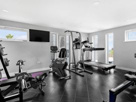 A gym with exercise equipment and windows at Huxham View and Annex in Stoke Canon