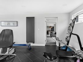 A gym with exercise equipment and a radiator at Huxham View and Annex Stoke Canon