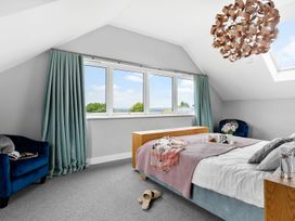 A bedroom with a bed and windows at Huxham View and Annex Stoke Canon