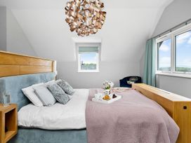 A bedroom with a bed and window at Huxham View and Annex Stoke Canon