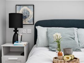 A bedroom with a bedside table and a tray on the bed at Huxham View and Annex Stoke Canon