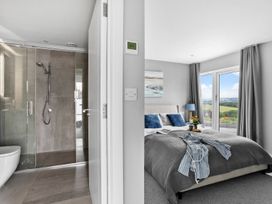 A bedroom with a bed and adjoining bathroom at Huxham View and Annex Stoke Canon
