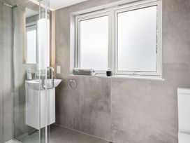 A bathroom with a shower, sink, toilet, and windows at Huxham View and Annex Stoke Canon