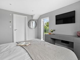 A bedroom with a bed and television at Huxham View and Annex Stoke Canon