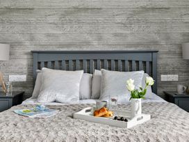 A bedroom with a bed and tray containing food at Huxham View and Annex Stoke Canon