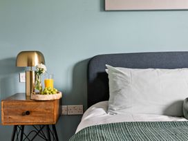 A bedroom with a nightstand, lamp, glass of orange juice, and grapes at Huxham View and Annex Stoke Canon