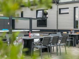 An outdoor seating area with chairs and a table at Huxham View and Annex Stoke Canon