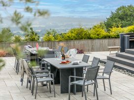 A patio with a table, chairs, wine and food at Huxham View and Annex Stoke Canon