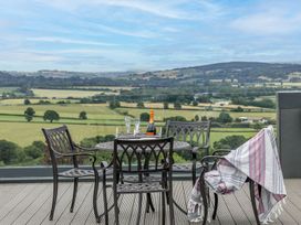 A table with chairs and champagne bottle on a balcony at Huxham View and Annex Stoke Canon