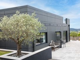 A modern building with a tree and patio area at Huxham View and Annex in Stoke Canon
