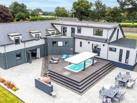 An outdoor area with a pool and patio seating at Huxham View and Annex Stoke Canon