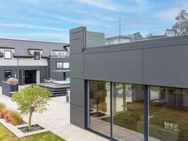 An outdoor view of a house with a deck and swimming pool at Huxham View and Annex Stoke Canon