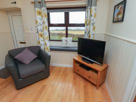 A living room with a chair and a television at Sunny Brae in Alnwick