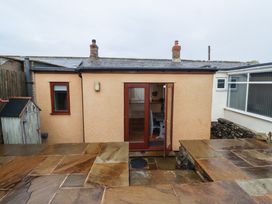 An exterior view of a small building with a door and patio stones at Sunny Brae in Alnwick