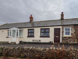 A cottage with a pathway and windows at Sunny Brae in Alnwick