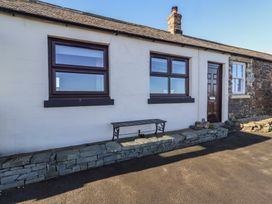 An exterior view of a cottage with windows and a door at 2 Sunny Brae Embleton