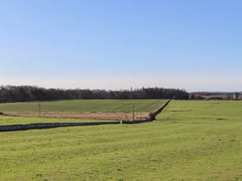 A field with power lines and a stone wall at 2 Sunny Brae in Embleton