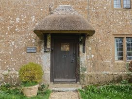 The entrance of Manor Cottage with a thatch roof and front door in Kingstone near Ilminster