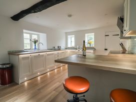 A kitchen with a wine bottle and glasses on a counter at Manor Cottage in Kingstone near Ilminster