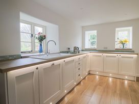 A kitchen with a sink and flowers in a vase at Manor Cottage Kingstone near Ilminster