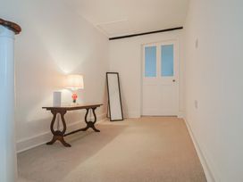 A hallway with a lamp and mirror at Manor Cottage Kingstone near Ilminster