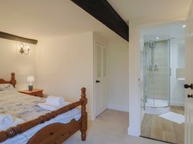 A bedroom with a bed and an attached bathroom at Manor Cottage in Kingstone near Ilminster