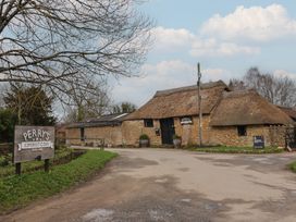 A building with a thatched roof and sign at Perry's Somerset Cider in Kingstone near Ilminster