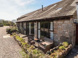 An outdoor seating area with a table and chairs at Tullythwaite Barn in Kendal