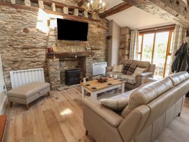 A living room with a fireplace and seating area at Tullythwaite Barn in Kendal