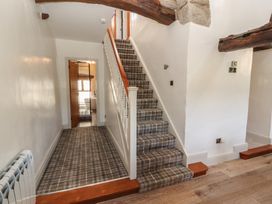 A hallway with stairs and a door at Tullythwaite Barn Kendal