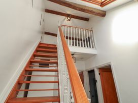 A staircase with wooden railing and doors at Tullythwaite Barn Kendal
