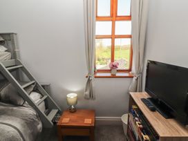 A bedroom with a bunk bed and a television at Tullythwaite Barn Kendal