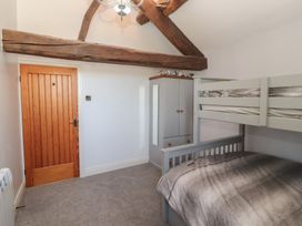 A bedroom with a bunk bed and cupboard at Tullythwaite Barn in Kendal