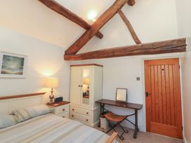A bedroom with a bed and a wardrobe at Tullythwaite Barn in Kendal