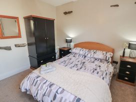 A bedroom with a bed and wardrobe at Tullythwaite Barn in Kendal