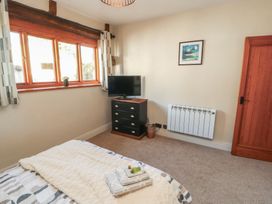A bedroom with a bed, tv, and chest of drawers at Tullythwaite Barn in Kendal