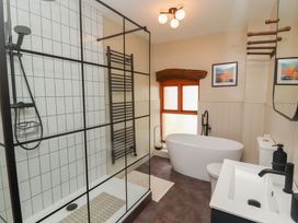 A bathroom with shower, bathtub, toilet, sink at Tullythwaite Barn Kendal