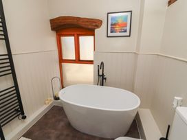A bathroom with a bath tub and a towel rail at Tullythwaite Barn in Kendal