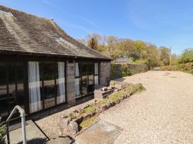 An outdoor area with a house and patio furniture at Tullythwaite Barn in Kendal