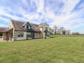 An exterior view of a house with grass and trees at Thimble Hill near Armathwaite