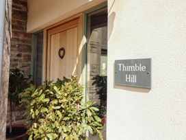 An entrance with a wooden door and a house number sign at Thimble Hill near Armathwaite