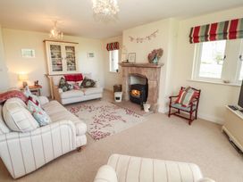 A living room with a fireplace and sofa at Thimble Hill near Armathwaite