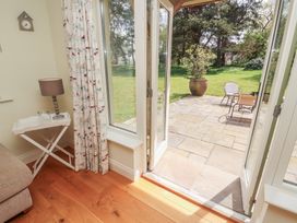 A living room opening to a patio with chairs and a potted plant at Thimble Hill near Armathwaite