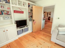 A living room with a television and shelves at Thimble Hill Near Armathwaite