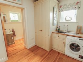 A washroom with a sink and washing machine at Thimble Hill Near Armathwaite