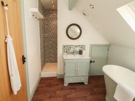 A bathroom with a bath tub, sink, and shower at Thimble Hill near Armathwaite