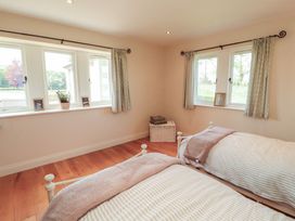 A bedroom with two beds and windows at Thimble Hill Near Armathwaite