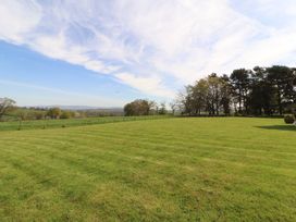 A garden with a grassy field and trees at Thimble Hill near Armathwaite