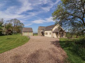 An exterior view of a house and garage with a gravel driveway at Thimble Hill near Armathwaite