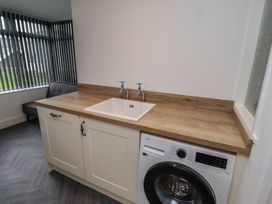 A laundry room with a sink and washing machine at 1 Sunnybrae Alnwick